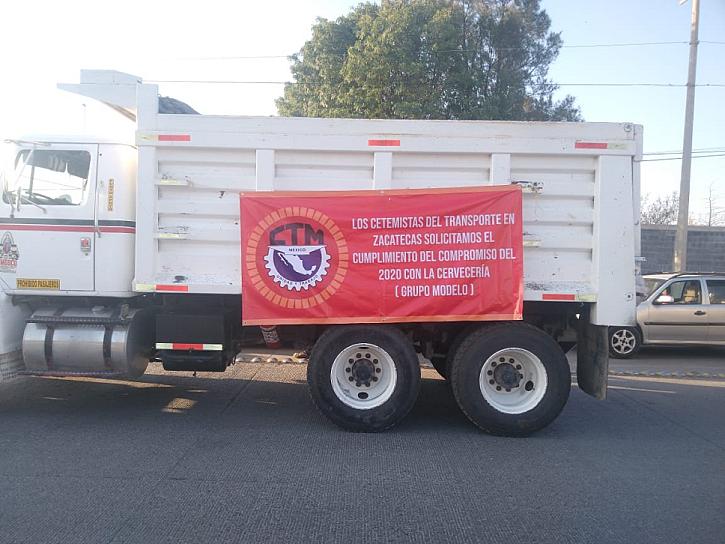 SE MANIFIESTAN TRANSPORTISTAS EN GRUPO MODELO; PIDEN QUE SE CONTRATEN CAMIONES LOCALES